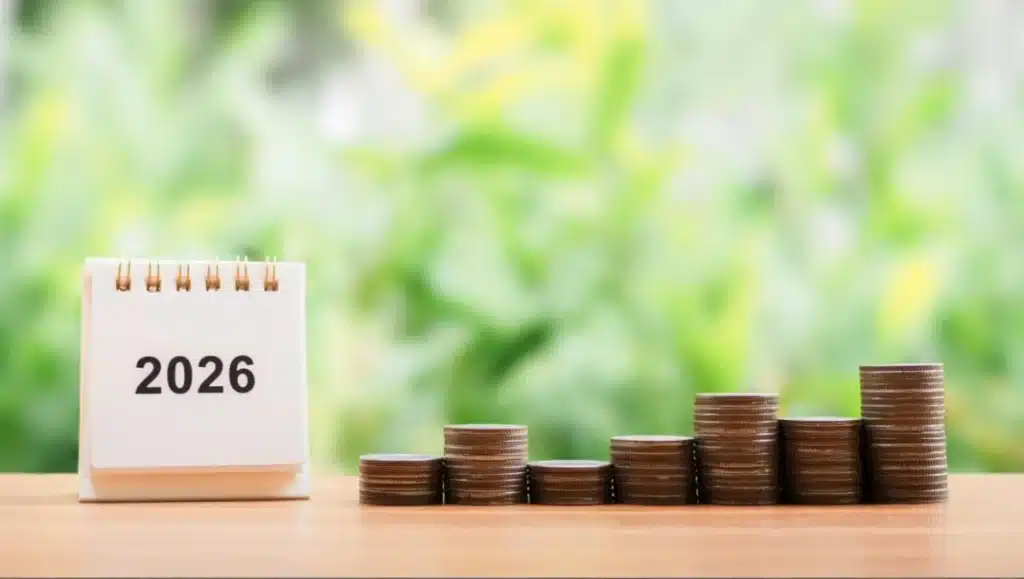 Calendrier 2026 posé à côté de piles de pièces de monnaie en croissance, illustrant la monétisation du compte épargne-temps (CET) des agents territoriaux.